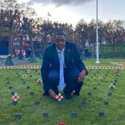 Bim Afolami places a Remembrance Cross in Parliament's Constituency Garden of Remembrance.