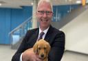 Hitchin Boys' School's head Fergal Moane with one of the eight week old puppies that visited the school this week