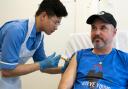 Nurse Christian Medina administers patient Steve Young with his first jab at UCLH.