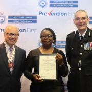 Nancy Segwete receives her award from Deputy Lieutenant of Hertfordshire His Honour Judge Michael Kay and Chief Constable Charlie Hall.