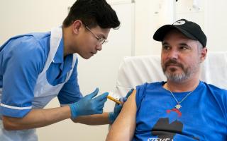 Nurse Christian Medina administers patient Steve Young with his first jab at UCLH.