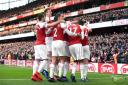 Arsenal's Pierre-Emerick Aubameyang (obscured) celebrates scoring his side's first goal of the game from the penalty spot with team-mates, as a banana skin is thrown onto the pitch by a fan, during the Premier League match at Emirates Stadium, London.PA