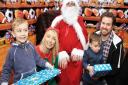 The Seber family receiving presents from Santa at the Melbourn Hub Grotto. Hugo and brother Willem with Dad James and Chloe from the Hub Cafe.