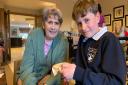 Care home resident Eileen shows Knebworth Primary pupil Jacob how to stitch.