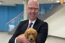 Hitchin Boys' School's head Fergal Moane with one of the eight week old puppies that visited the school this week