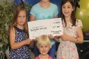 Olivia Woods, 7, Emily Woods, 10, Ruby Gibson, 6 and Isla Woods with a cheque for money which they raised by making and selling cakes