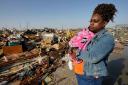 Wonder Bolden cradles her year-old granddaughter Journey Bolden as she surveys the remains of her mother’s tornado-demolished mobile home in Rolling Fork, Mississippi (Rogelio V. Solis/AP/PA)