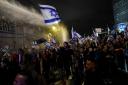 Israeli police used water cannon to disperse people in Tel Aviv protesting against plans by Benjamin Netanyahu’s government to overhaul the judicial system (Ariel Schalit/AP)
