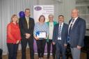Jo Lawson with her award. From L to R: Jane Gibson, governor; Tony Fitzpatrick, executive headteacher; Jo Lawson; Mary Patrick, governor; Mohammed Ashraf, governor; Professor Sir Tim Wilson, deputy lieutenant of Hertfordshire.