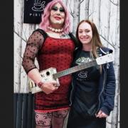 Michelle Gibbs presented the unique guitar to drag performer Magenta Slipperz.
