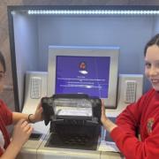 Caitlyn and Evie took the money raised to the bank to deposit.