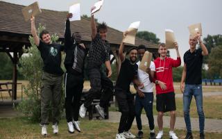 Students at Nicholas Breakspear Catholic School in St Albans jump with their A-level results envelopes